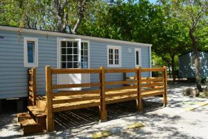 a large wooden bench in front of a tiny house at Camping La Aventura Playa in Daimuz