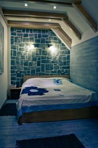 a bedroom with a bed and a brick wall at Apartmani Vila Bjelasica in Kolašin