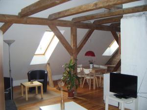 a living room with wooden beams and a dining room at Altstadt-Pension-Potsdam in Potsdam