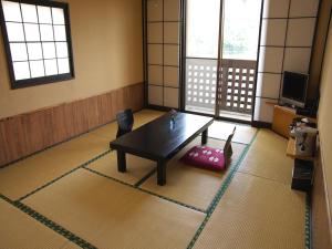 a living room with a table and a chair at Kirishima miyama hotel in Kirishima