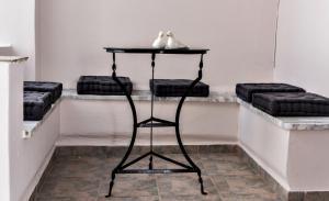 a black table with three stools in a room at Aleka's Rooms in Tinos