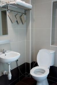 a bathroom with a toilet and a sink at Maple Inn in Kuala Lumpur