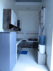 eine weiße Küche mit einer Theke und einem Kühlschrank in der Unterkunft Villa Zam Zam Syariah in Puncak