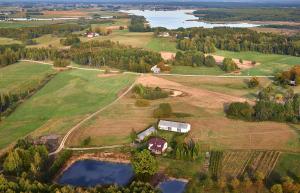 uma vista aérea de uma quinta com uma casa e um lago em Gospodarstwo agroturystyczne Biebrzanska Goscina em Karcewo
