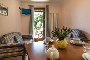 sala de estar con mesa de madera y 2 sillas en Appartamenti Livia, en Gargnano