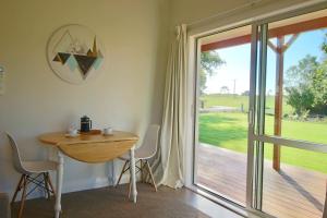 a dining room with a table and a sliding glass door at Walnut Lodge B&B in Matamata