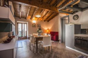 eine Küche und ein Esszimmer mit einem Tisch und einem Kühlschrank in der Unterkunft Case Vacanze ai Burattini in Adrara San Rocco