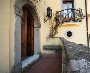 an entrance to a building with a door and a balcony at The Clock Houses Borgo Gallodoro in Letojanni