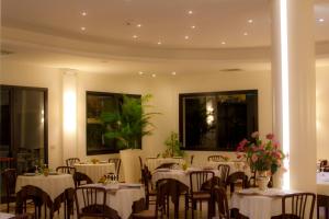 a dining room with tables and chairs with flowers on them at Hotel Reggiana in Riccione