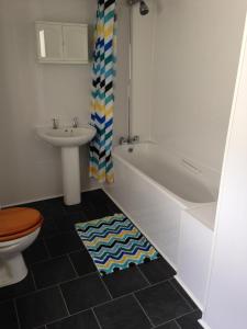 y baño con bañera, lavabo y aseo. en Ishara Apartment, en Weymouth
