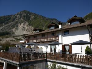 a building with a balcony with umbrellas next to a pool at Garnì Al Laghet in Tenno