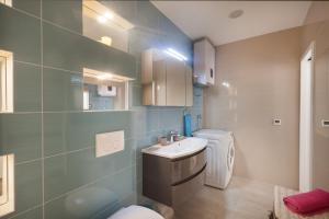 a bathroom with a sink and a washing machine at Studio Apartment Tia in Makarska +14 photos