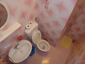 a pink bathroom with a sink and a toilet at Omiš apartment on the beach in Omiš