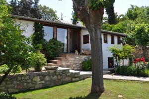 a house with a stone wall and a tree at Garden House in Selçuk