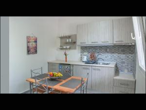 a kitchen with a table with a bowl of fruit on it at Sunray Apartments in Skala Sotiros