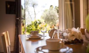 a table with cups and glasses and a window at Appartamenti Livia in Gargnano