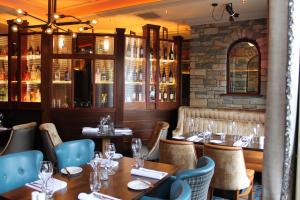 a restaurant with wooden tables and chairs and a stone wall at Abbey Hotel Donegal in Donegal
