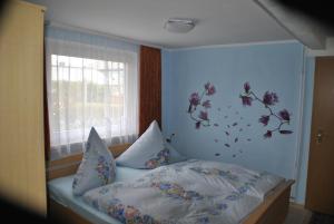 ベンネッケンシュタインにあるGuest house Mückenheimのベッドルーム1室(花の壁掛けのベッド1台付)