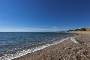 a beach with a rocky shoreline and the ocean at Villa Nastazia in Kiotari