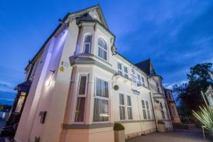 un grande edificio bianco con una torre di A Park View Hotel a Wolverhampton