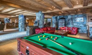a living room with a pool table in a house at CGH Résidences & Spas Les Cimes Blanches in La Rosière