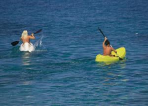 a man and a woman in the water on kayaks at Villaggio Athragon in Capo Vaticano