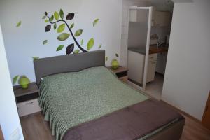 a bedroom with a bed with a plant on the wall at Guest House Fortuna in Novigrad Istria