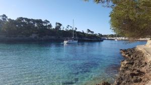 a sailboat in a river with acknowled at Agroturisme Na Martina in Portopetro