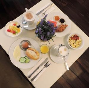 a table with plates of breakfast foods on it at Motel Plus Berlin in Berlin