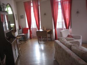 Les choucas في لوشون: غرفة معيشة مع ستائر حمراء وأريكة