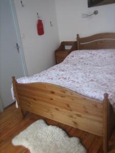 ルションにあるLes choucasのベッドルーム1室(木製ベッド1台、ラグ付)