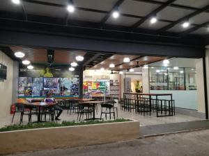 a woman sitting at a table in a restaurant at Hotel ASRC in Alor Setar