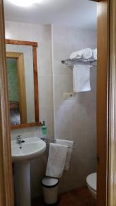 a bathroom with a sink and a toilet and a mirror at Albergue de Portilla in Portilla de la Reina