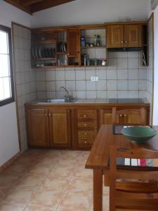 a kitchen with wooden cabinets and a wooden table at Casa Rural Arguamul in Vallehermoso