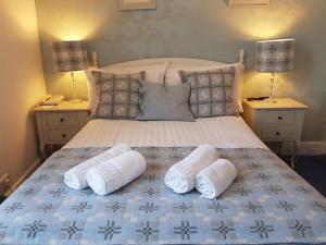 a bedroom with a bed with two towels on it at Gwesty'r Marine Hotel & Spa in Aberystwyth