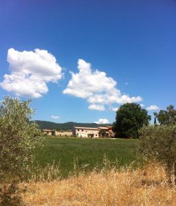 a field with a house in the background with clouds at Domaine De Camp Joyeux in Puget-Ville