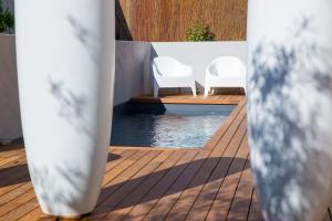 dos sillas blancas sentadas junto a una piscina en Chambre d'Hôtes Arima, en Biarritz