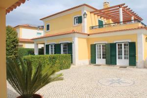 a house with a courtyard in front of it at Spacious Villa in Azeitão (with private pool) in Azeitao