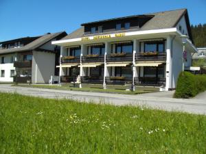 - un bâtiment avec balcon sur le côté d'une rue dans l'établissement Hotel Rheingold Garni, à Titisee-Neustadt