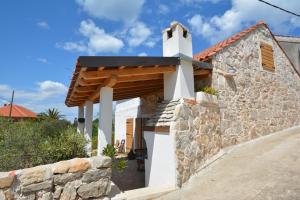a white chapel with a stone wall at Dream house in Zaglav