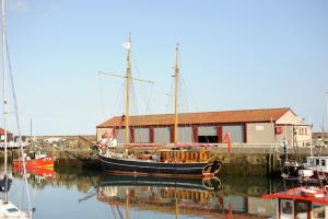 a boat docked next to a building in a harbor at The Wee Anchor in Arbroath