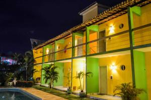 a yellow and green building with a swimming pool at Pousada Maturi - Pipa in Pipa