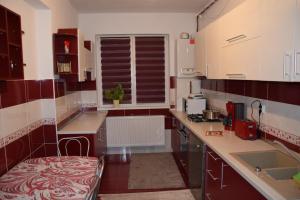 eine Küche mit roten und weißen Schränken und einem Fenster in der Unterkunft Apartament Selimbar in Sibiu