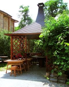 a wooden gazebo with a table and a bench at Green Style in Kyiv