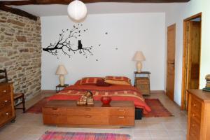 een slaapkamer met een bed en een boom aan de muur bij La Colline du Chat Perche in Connac +49 foto's