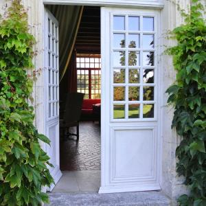 uma porta aberta para um quarto com uma cadeira atrás em Le Claveau em Paulnay