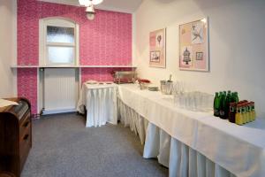 a row of tables in a room with pink walls at Pension Pod věží in Kolín