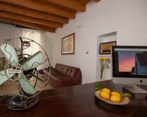 a room with a desk with a computer monitor and a bowl of fruit at Dimora Nonna Rosa in Conversano