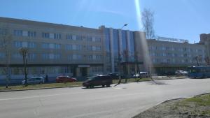 a car parked in a parking lot in front of a building at Severnye Zori Hotel in Cherepovets