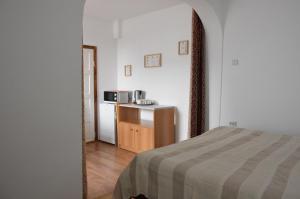 a bedroom with a bed and a kitchen with a microwave at Central city AP in Sibiu